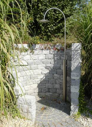 mit kalt-warm Mischer umschlossen von Natursteinmauer harmonisch in den Garten integriert